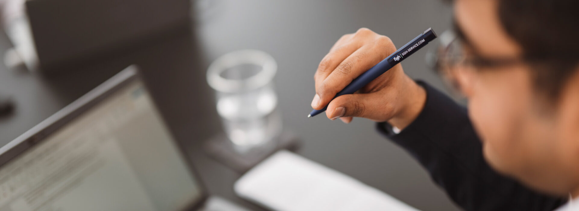 Mitarbeiter in einer Business-Besprechung mit Laptop und Stift, konzentriert auf strategische Abstimmung und strukturierte Unternehmensprozesse.
