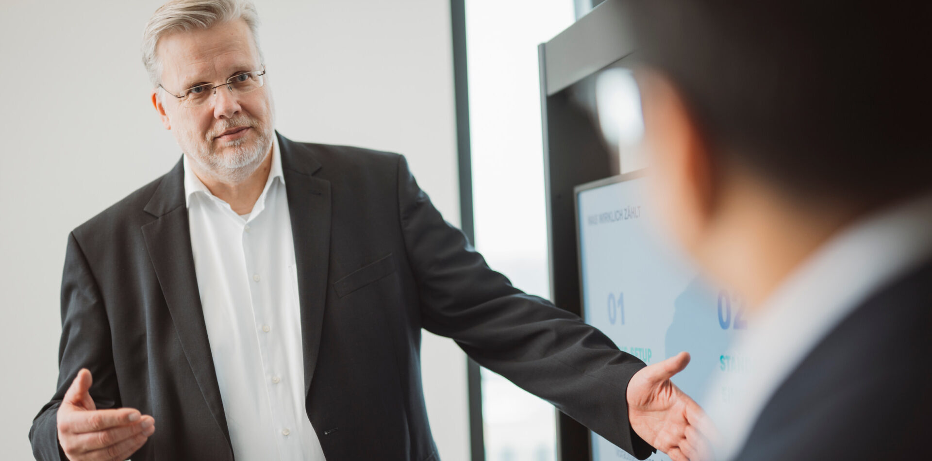 Mitarbeiter pr&auml;sentiert in einer Business-Besprechung strukturierte Unternehmens- oder Finanzprozesse an einem Bildschirm.