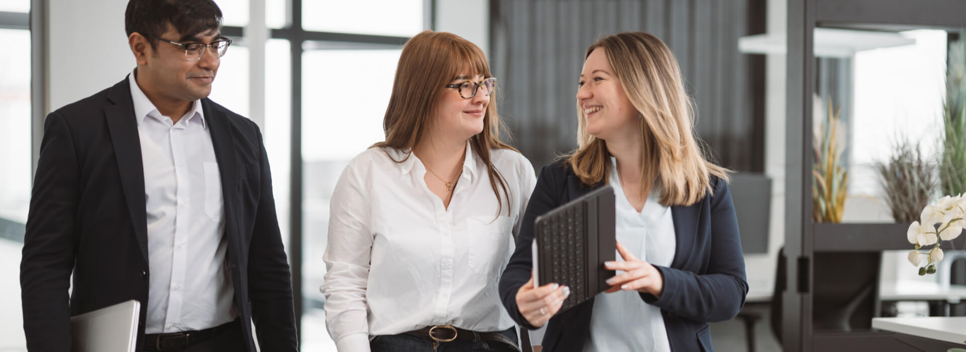 Drei Mitarbeitende im Büro besprechen Accounting Services und digitale Buchhaltungsprozesse.