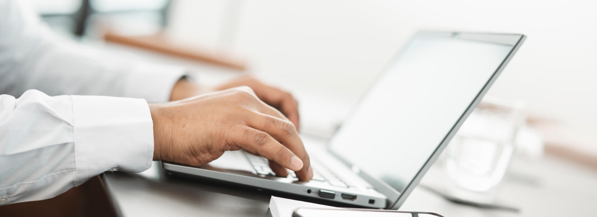Mitarbeiter arbeitet am Laptop mit einem E-Procurement-System für elektronische Beschaffung.