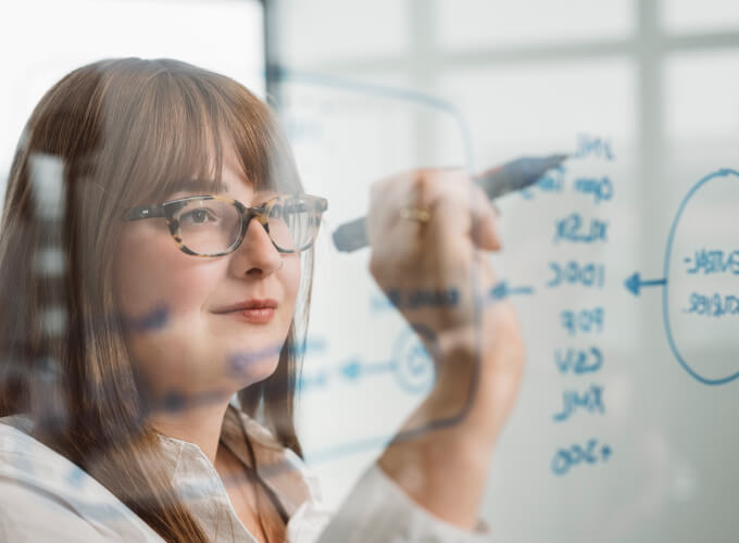 Mitarbeiterin skizziert einen digitalen Rechnungsworkflow.