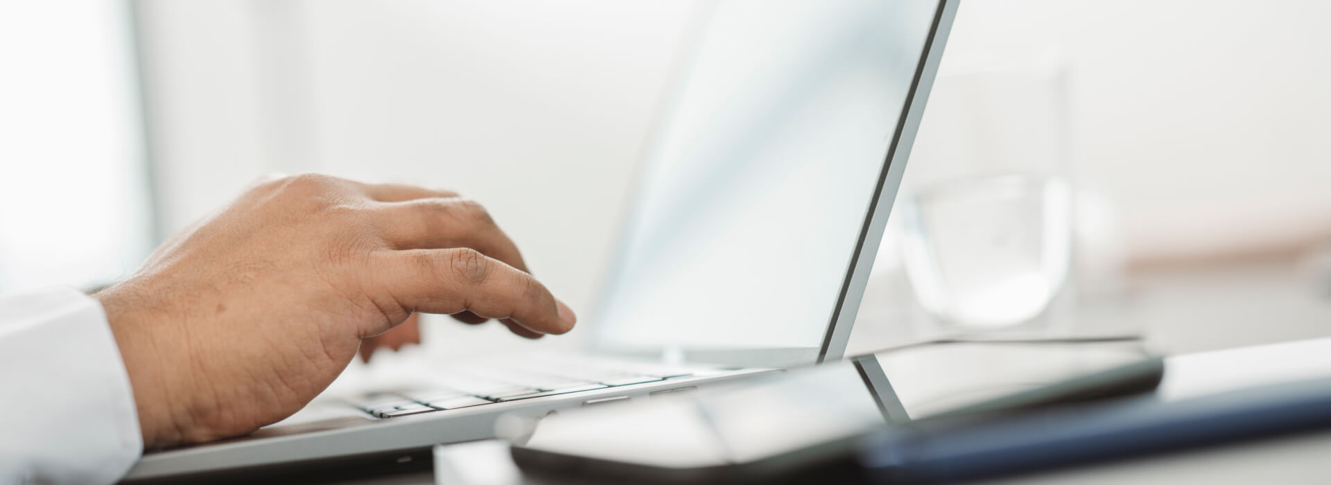 Hand am Laptop beim Erstellen und Versenden einer XRechnung im XML-Format.